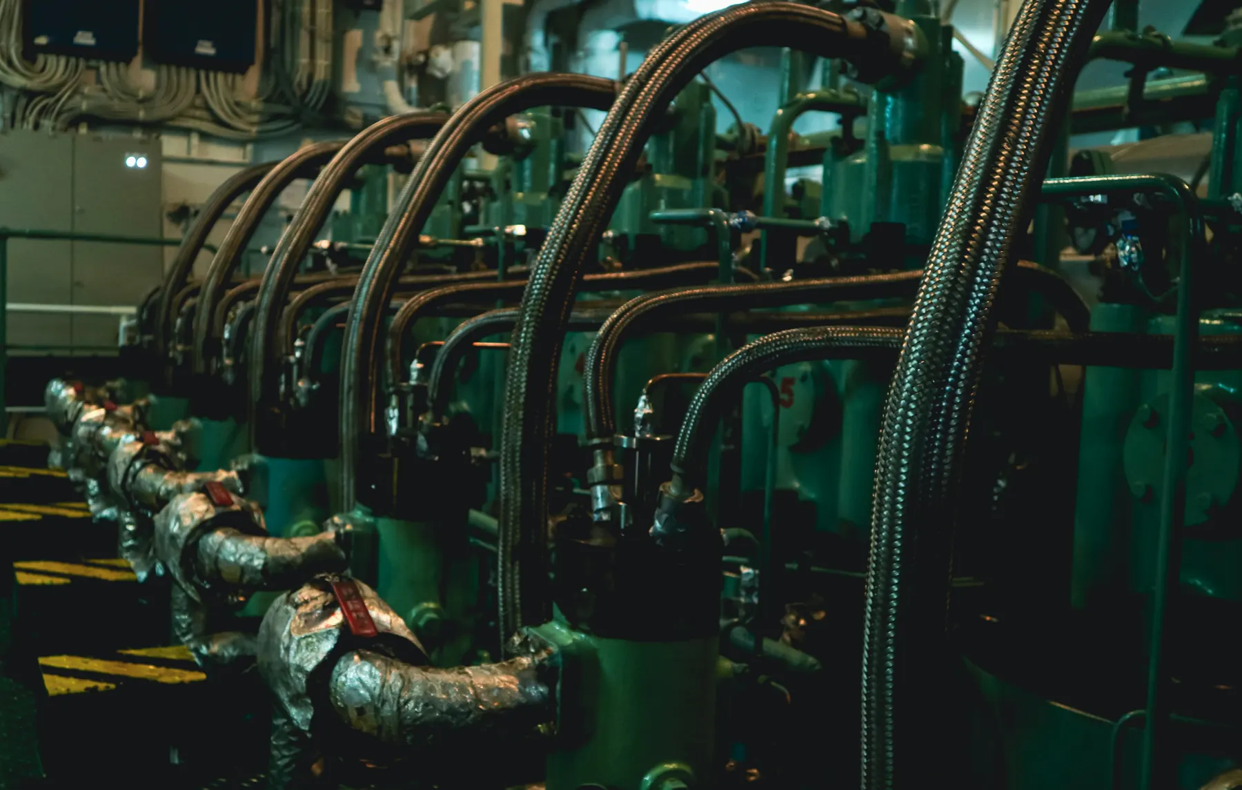 Engine room of a ship with braided hoses and pipes